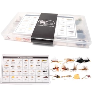 May include: A clear plastic fly fishing kit with a black band that reads "Premium Fly Fishing Kit". The kit includes a fly identification guide and various artificial flies in a range of colors and styles, perfect for anglers.