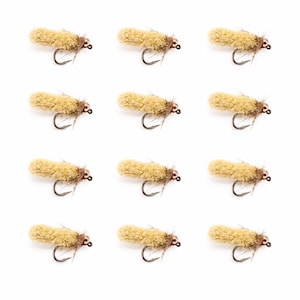 May include: A set of twelve identical fishing flies arranged in a grid. Each fly features a fuzzy, tan-colored cylindrical body, a metallic copper-toned bead head, and a curved metal hook with thin, wispy brown fibers extending from the base.