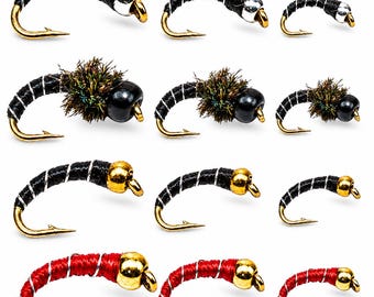 May include: A collection of twelve fishing flies arranged in four rows. The flies feature curved gold hooks, black or red bodies wrapped with silver wire, and various head designs including silver beads, black beads, and gold beads.