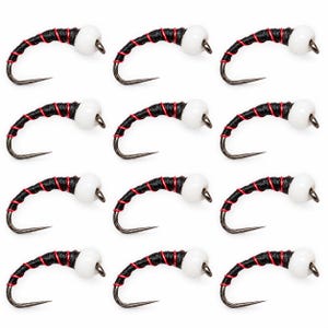 Puede incluir: Un conjunto de doce moscas de pesca dispuestas en una cuadrícula. Cada mosca presenta un anzuelo de metal curvado, un cuerpo negro envuelto con hilo rojo fino y una cuenta blanca lisa colocada cerca del ojo del anzuelo, creando un aspecto uniforme.