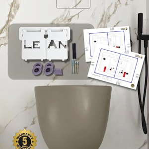 May include: A modern, gray toilet bowl with a matching flush plate and a white, rectangular flush button. The image includes a white flush mechanism with the word "LEAN" and diagrams. A gold warranty seal is visible.