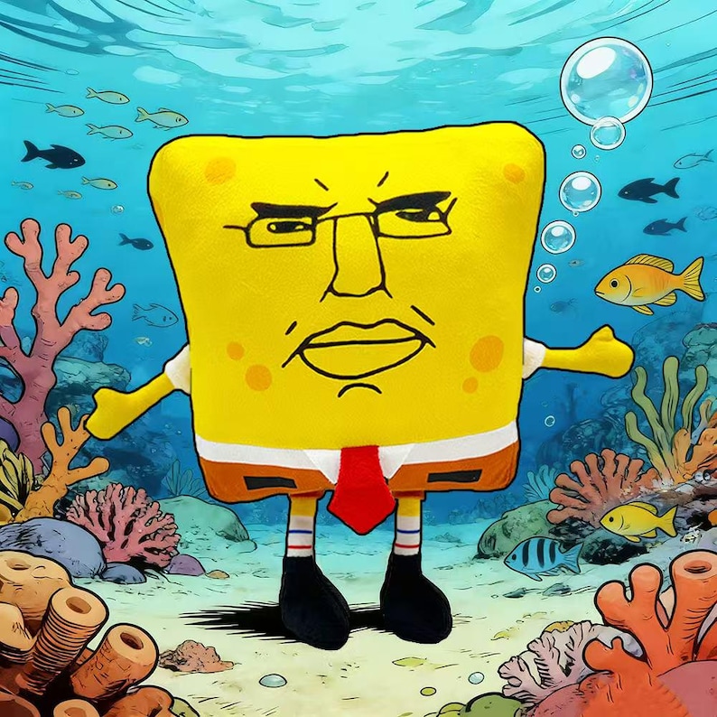 May include: A yellow plush toy resembling a cartoon character with a stern expression, wearing glasses, a red tie, and a white shirt. The toy is set in an underwater scene with fish, coral, and bubbles.