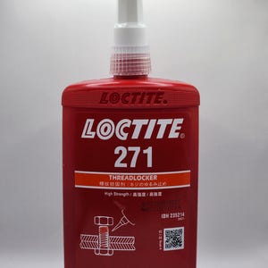 May include: A red Loctite 271 Threadlocker bottle with a white nozzle. The bottle has the Loctite logo and product information, including "250ml". The product is designed for high-strength applications.