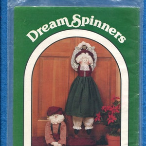 May include: A package for a Dream Spinners craft kit. The kit features two fabric dolls, one hanging from a door and the other standing. The text reads "#140 - American Celebration" and "28" doorknob/draft stopper dolls with adjustable length."