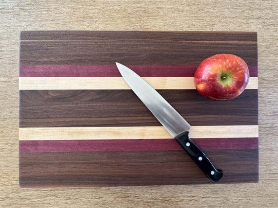 Walnut, maple, AND purple heart wood — that vivid violet stripe is an instant visual wow on a butcher-block charcuterie board.