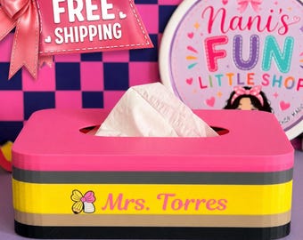 May include: A rectangular tissue box cover designed to resemble a pencil with a pink top, gray band, yellow middle section, tan accent, and black base. The yellow section features a small pencil icon with a pink bow and the text Mrs. Torres.