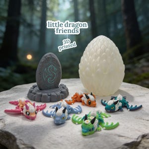 Puede incluir: Una colección de pequeñas figuras de dragón articuladas en rosa, azul, naranja y verde, acompañadas de un huevo grande y texturizado de color blanco roto y un pedestal gris similar a una piedra con un emblema de dragón. El texto dice: little dragon friends 3D printed.