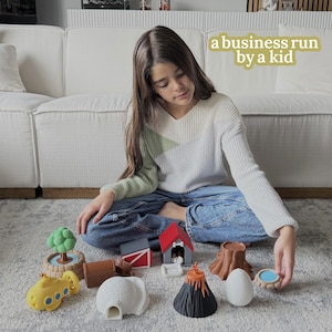 May include: A young person sits surrounded by colorful toy structures, including a yellow submarine, a red dog house, a brown tree stump, and a white igloo. The text "a business run by a kid" is in the background.