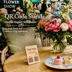 Könnte beinhalten: Ein hölzerner QR-Code-Ständer mit dem Text „Ihr Logo“ und „Ihr Name“. Der Ständer steht auf einem Holztisch mit einem Blumenarrangement und Gebäck. Der Text „Einfach. Elegant. Nachhaltig.“ ist ebenfalls sichtbar.