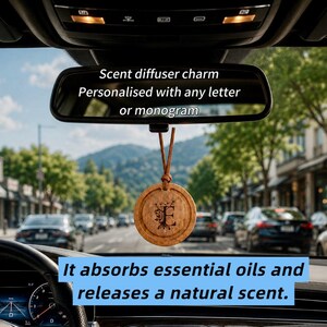 Puede incluir: Un difusor de aroma redondo de madera para coche que cuelga del espejo retrovisor. El dije presenta una letra E grabada con láser con detalles florales y está suspendido por un cordón de cuero marrón. El texto dice: Scent diffuser charm Personalised with any letter or monogram. It absorbs essential oils and releases a natural scent.
