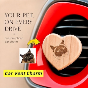 May include: A heart-shaped wooden car vent charm featuring a laser-engraved portrait of a cat. The text reads: YOUR PET, ON EVERY DRIVE, custom photo car charm, and Car Vent Charm. The charm is attached to a black car air vent.