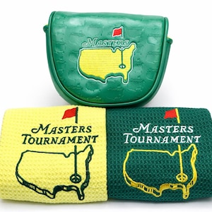 Puede incluir: Funda verde para la cabeza del palo de golf y dos toallas de golf. La funda y las toallas presentan el logotipo del Masters Tournament, que incluye una bandera roja, la palabra "Masters" y un mapa del campo en amarillo y verde.