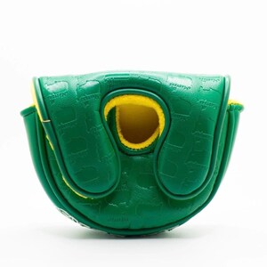 May include: A green golf putter cover with a yellow interior. The cover is embossed with a repeating pattern and the word "Masters". The cover is made of a durable material and has a magnetic closure.