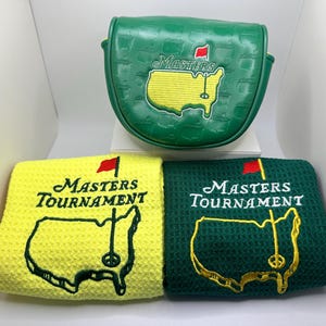 Puede incluir: Una funda verde para la cabeza del palo de golf y dos toallas de golf. La funda es verde con el logotipo de Masters bordado en amarillo y blanco. Las toallas son amarillas y verdes, cada una con el logotipo y el mapa del Masters Tournament.