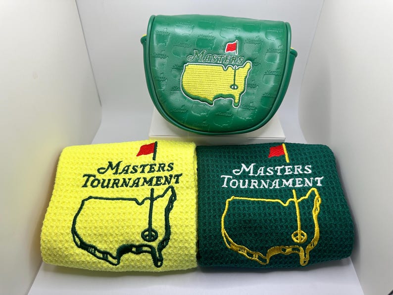 Puede incluir: Una funda verde para la cabeza del palo de golf y dos toallas de golf. La funda es verde con el logotipo de Masters bordado en amarillo y blanco. Las toallas son amarillas y verdes, cada una con el logotipo y el mapa del Masters Tournament.