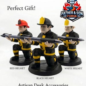 May include: Three firefighter figurines kneeling on circular black bases, each holding a black pen horizontally. The figures wear black jackets with yellow reflective stripes and helmets in red, black, and white. Text includes Father & Son Forge.