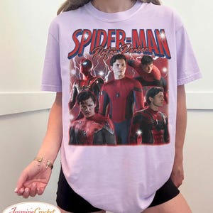 以下が含まれることがあります： スパイダーマンのグラフィックと「SPIDER-MAN Peter Parker」の文字が赤と青でプリントされた、薄紫色のTシャツ。デザインには、スパイダーマンの複数の画像が含まれています。ファン向けのカジュアルウェアです。