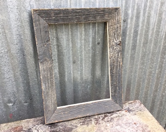 May include: A rustic wooden picture frame with a dark brown finish. The frame has a simple design with a slightly raised edge.