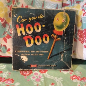 May include: A vintage game box with a blue background and yellow, red, and orange lettering that reads "Can you do Hoo-Doo". The box features a yellow, green, and red character with a stick.