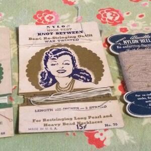 Könnte beinhalten: Drei Pakete Nylonfaden zum Umfädeln von Halsketten. Die mittlere Packung zeigt eine Frau mit einer Perlenkette und dem Text "Nylon High Test Knot Between Bear's Re-Stringing Outfit Wax Twisted Length 100 Inches - 2 Strand For Restringing Long Pearl and Heavy Bead Necklaces Made in U.S.A. 15¢ No. 70". Die Packung links hat den Text "N Outfit Lasp 2 Inches LL Style Ces No. 88". Die Packung rechts hat den Text "Bucilla Improved Nylon Heel 'n Toe Yarn Re-enforcing-Darning-Mending Twist-It-Darn-It-Mend-It For re-inforcing heels on socks, fingers of gloves articles at points Directions on other 60 Yard".
