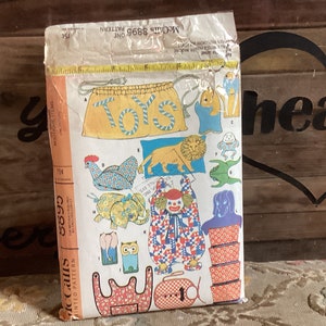 May include: A vintage McCall's sewing pattern for making stuffed toys. The pattern includes instructions for making a lion, a clown, a frog, an elephant, an owl, a chicken, and a dog. The pattern is labeled "McCall's 8869 Pattern One 75c".