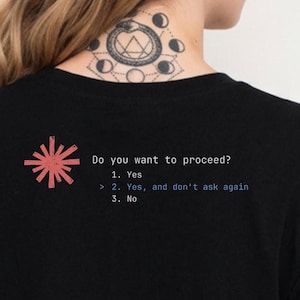 Könnte beinhalten: Schwarzes T-Shirt mit rotem Sternmuster und dem Text "Do you want to proceed?" gefolgt von nummerierten Optionen: 1. Ja, 2. Ja, und nicht mehr fragen, und 3. Nein. Ein lässiges Kleidungsstück.