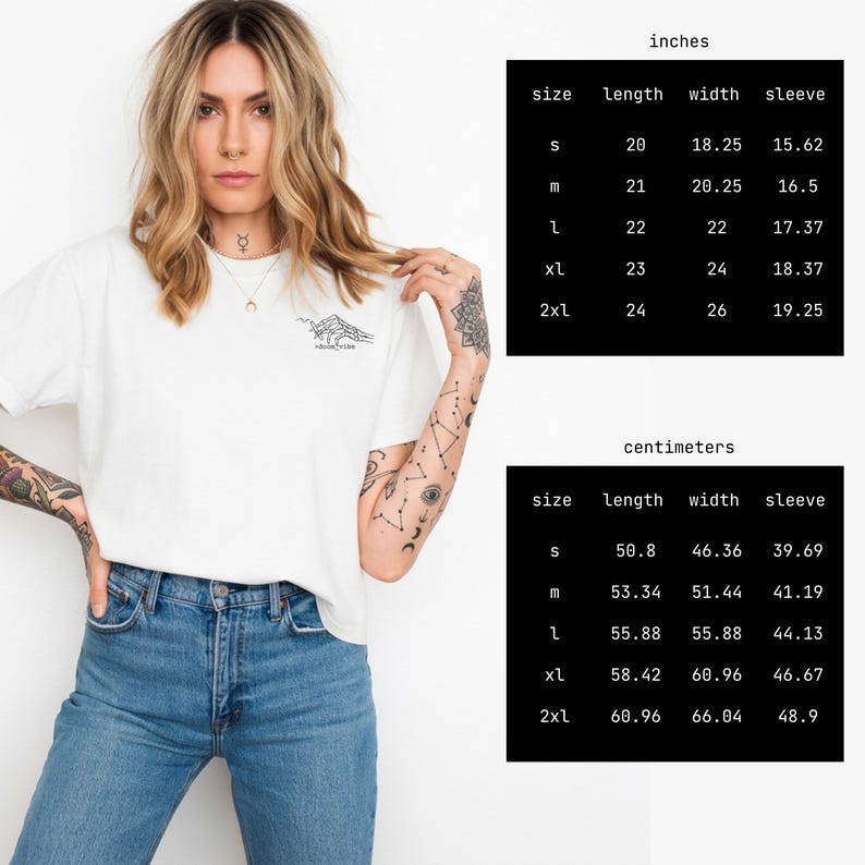 Puede incluir: Camiseta blanca con un gr&aacute;fico de monta&ntilde;a y el texto "Mountain Vibe". La imagen incluye una tabla de tallas en cent&iacute;metros, con medidas de largo, ancho y manga para las tallas S a 2XL.