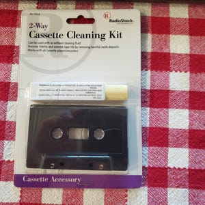 May include: A RadioShack 2-Way Cassette Cleaning Kit in original packaging. The white card features the text 2-Way Cassette Cleaning Kit, model 44-1162A, and includes a black cassette-shaped cleaning device and a small white bottle of cleaning fluid.