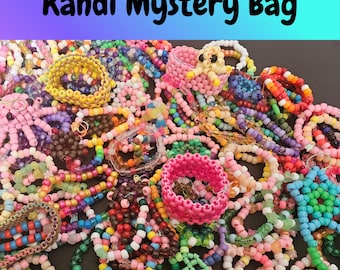 Può includere: Un assortimento colorato di braccialetti e accessori Kandi. L'immagine presenta una varietà di braccialetti di perline in vari colori, tra cui rosa, giallo, blu e verde. Il testo "Kandi Mystery Bag" è visualizzato nella parte superiore dell'immagine.