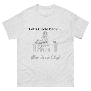 May include: Light gray t-shirt with the text "Let's Circle back... (When She's In College)". The graphic shows a person working on a laptop at a desk with a child nearby. The design is in black.