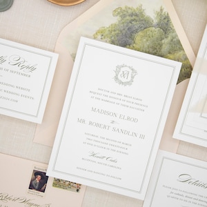 May include: Elegant wedding invitation suite with a light beige background. The invitation features a formal layout with a decorative border and a floral monogram. Includes matching RSVP cards, details cards, and stamps.