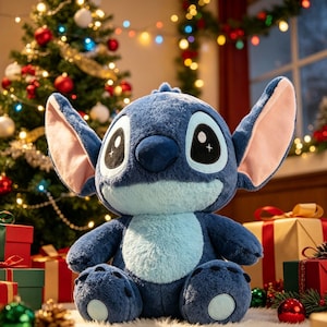 Puede incluir: Un peluche azul de Stitch con orejas grandes, ojos negros y una barriga azul claro. El peluche está sentado frente a un árbol de Navidad y regalos envueltos, creando una escena festiva navideña.