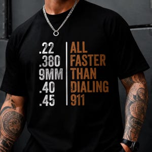 Könnte beinhalten: Ein schwarzes Kurzarm-T-Shirt mit weißem Text, der .22, .380, 9MM, .40 und .45 auflistet, getrennt durch eine vertikale Linie von braunem Text, der ALL FASTER THAN DIALING 911 lautet. Das Shirt hat einen Rundhalsausschnitt und eine Standardpassform.