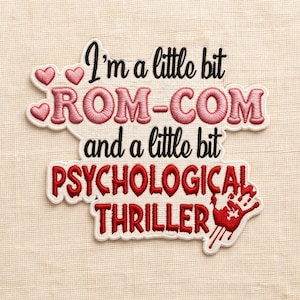 May include: Embroidered patch with the text "I'm a little bit ROM-COM and a little bit PSYCHOLOGICAL THRILLER." The top section has pink hearts and lettering. The bottom section has red lettering and a red hand graphic.