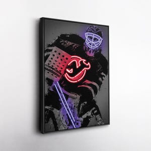 May include: A framed art print featuring a hockey goalie in a black and white artistic style. The image is accented with neon-style red and purple lines and the team logo. The goalie's mask and pads are visible.