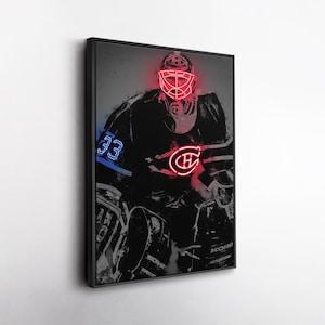 May include: Framed artwork depicting a hockey goalie in a black and white illustration. The goalie's mask and team logo are highlighted with a neon red glow, and the number 33 is in blue. The artwork is presented in a black frame.