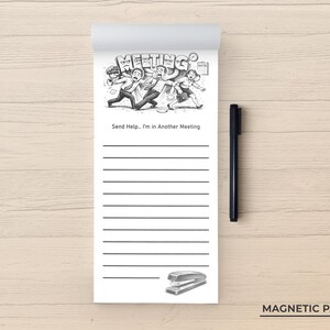 May include: A white magnetic notepad with a black pen. The notepad features a black and white cartoon illustration of people running away from the word "MEETING". The text "Send Help... I'm in Another Meeting" is below the illustration.
