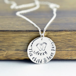 May include: Silver necklace with a round pendant that says "This child I have my Avery" with a pair of baby footprints and a heart.