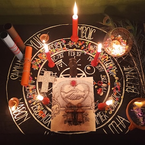 Puede incluir: Un altar m&iacute;stico con una superficie negra, adornado con velas, una cruz decorativa y una ilustraci&oacute;n central de manos entrelazadas. El altar est&aacute; decorado con cuentas de colores y plumas de pavo real, creando un ambiente espiritual. El texto en el altar incluye las palabras: YULE, IMBOLC, COISCE, SAMHAIN, MABON, BELTANE, y LITHA.