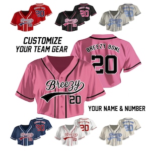 Può includere: Una collezione di maglie da baseball personalizzabili in vari colori, tra cui rosso, nero, rosa, blu e bianco. Ogni maglia presenta il testo "Breezy" e il numero "20". L'immagine include anche il testo "Personalizza la tua attrezzatura da squadra" e "Il tuo nome e numero".