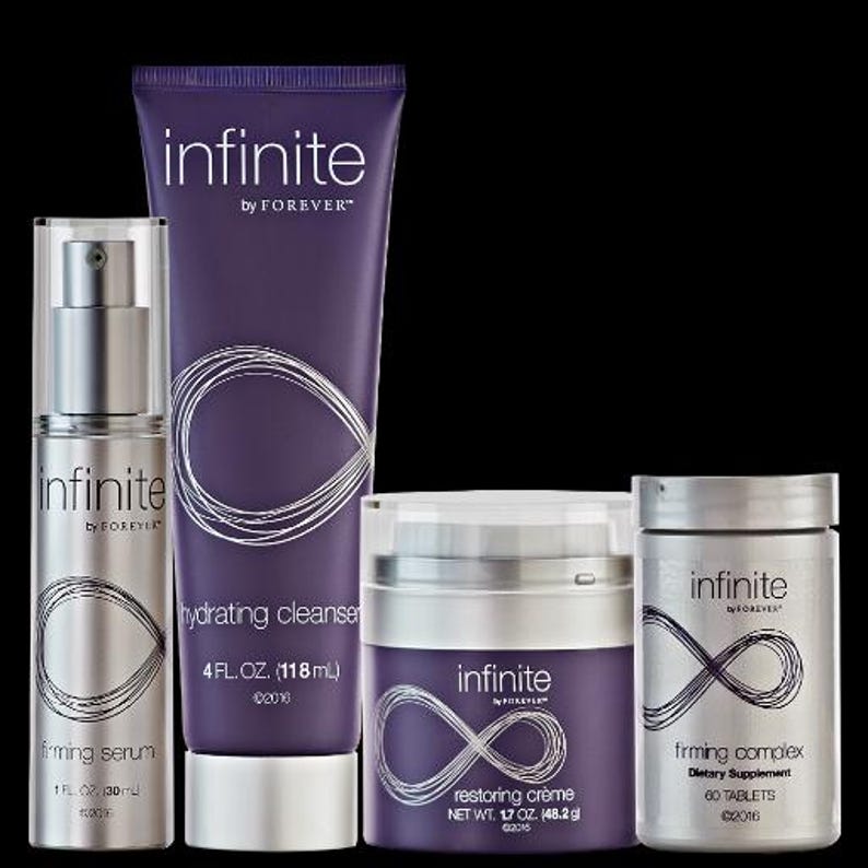 K&ouml;nnte beinhalten: Eine Sammlung von Hautpflegeprodukten, darunter ein straffendes Serum, ein feuchtigkeitsspendender Reiniger, eine Restoring Cr&egrave;me und ein straffender Komplex. Die Produkte sind in silber- und lilafarbenen Verpackungen mit dem Markennamen "infinite by FOREVER" und einem Unendlichkeitszeichen.