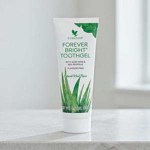 Op de afbeelding: Een witte tube Forever Bright Toothgel met groene accenten en tekst. De tube toont de merknaam en productdetails, waaronder "Natural Mint Flavor" en "Fluoride-vrij". De tube bevat 130 g product.
