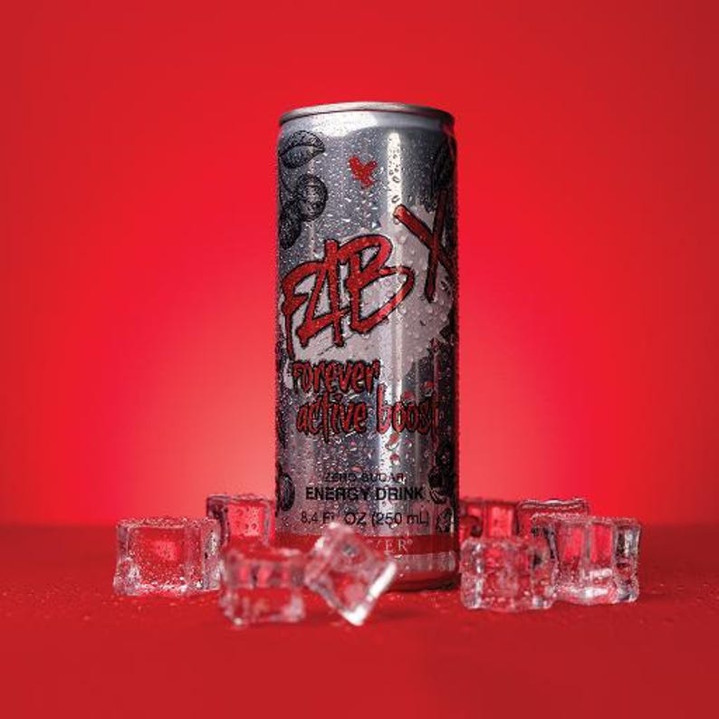 May include: A silver energy drink can with the text "FAB X forever active boost" in red, surrounded by ice cubes on a red background. The can is 250 ml.
