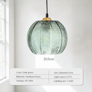 May include: Dark green glass pendant light with a diameter of 15cm. The light fixture has a textured, ribbed design and a gold-colored metal cap. The light hangs from a black cord and is suitable for lighting areas of 5-10 square meters.