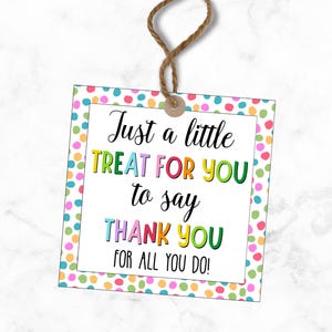May include: A square gift tag with a white background and colorful polka dots around the border. The tag has the text "Just a little TREAT FOR YOU to say THANK YOU FOR ALL YOU DO!" in various colors. A brown string is attached.