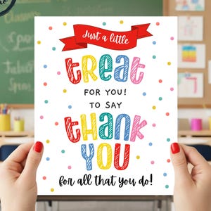 May include: A colorful thank you card with the text "Just a little treat for you! To say thank you for all that you do!" The card is held in front of a classroom background.