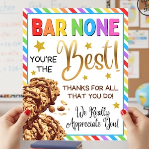 May include: A colorful print with the words "BAR NONE YOU'RE THE BEST!" in a mix of fonts and colors. The print includes a graphic of a chocolate-covered granola bar and the text "THANKS FOR ALL THAT YOU DO! We Really Appreciate You!"