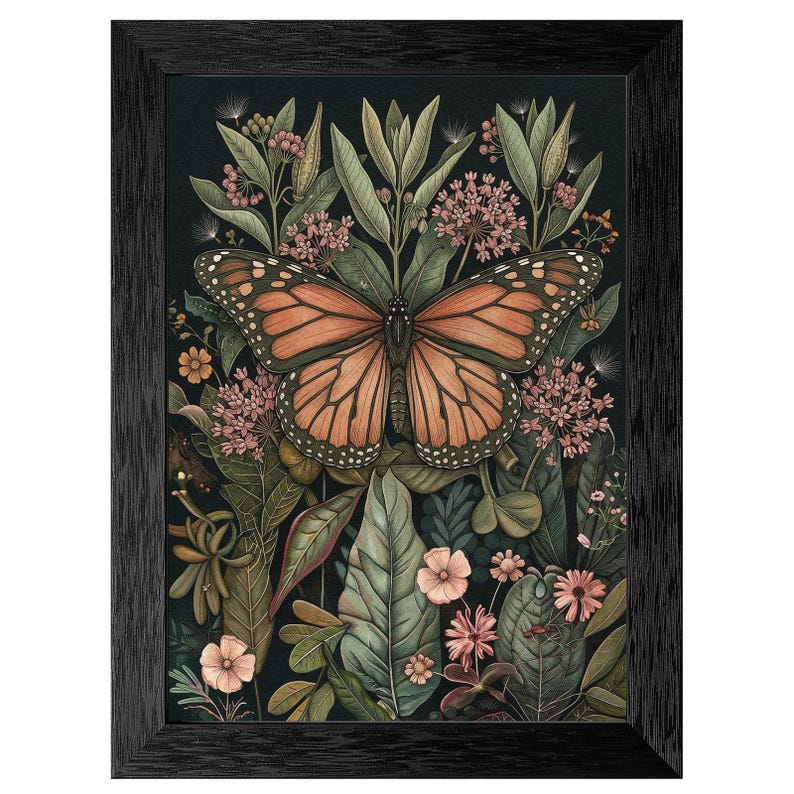 May include: A framed art print featuring a monarch butterfly with orange and black wings, surrounded by lush green foliage and pink flowers. The artwork has a dark background and is encased in a black frame, creating a nature-inspired aesthetic.