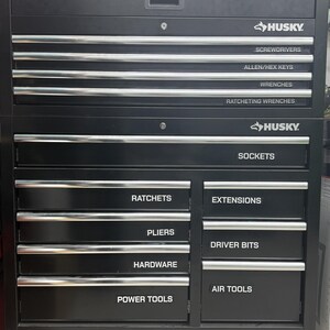 May include: A black Husky metal tool chest with multiple drawers featuring silver handles and white labels. The labels read: Screwdrivers, Allen/Hex Keys, Wrenches, Ratcheting Wrenches, Sockets, Ratchets, Pliers, Hardware, Power Tools, Extensions, Driver Bits, and Air Tools.