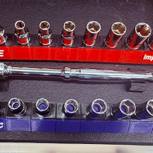 May include: A set of chrome sockets and a ratchet wrench organized in a toolbox. The sockets are arranged on red and blue holders labeled "3/8 SAE" and "3/8 METRIC". The ratchet wrench is marked "USA". The holders are labeled "ImpactModel".